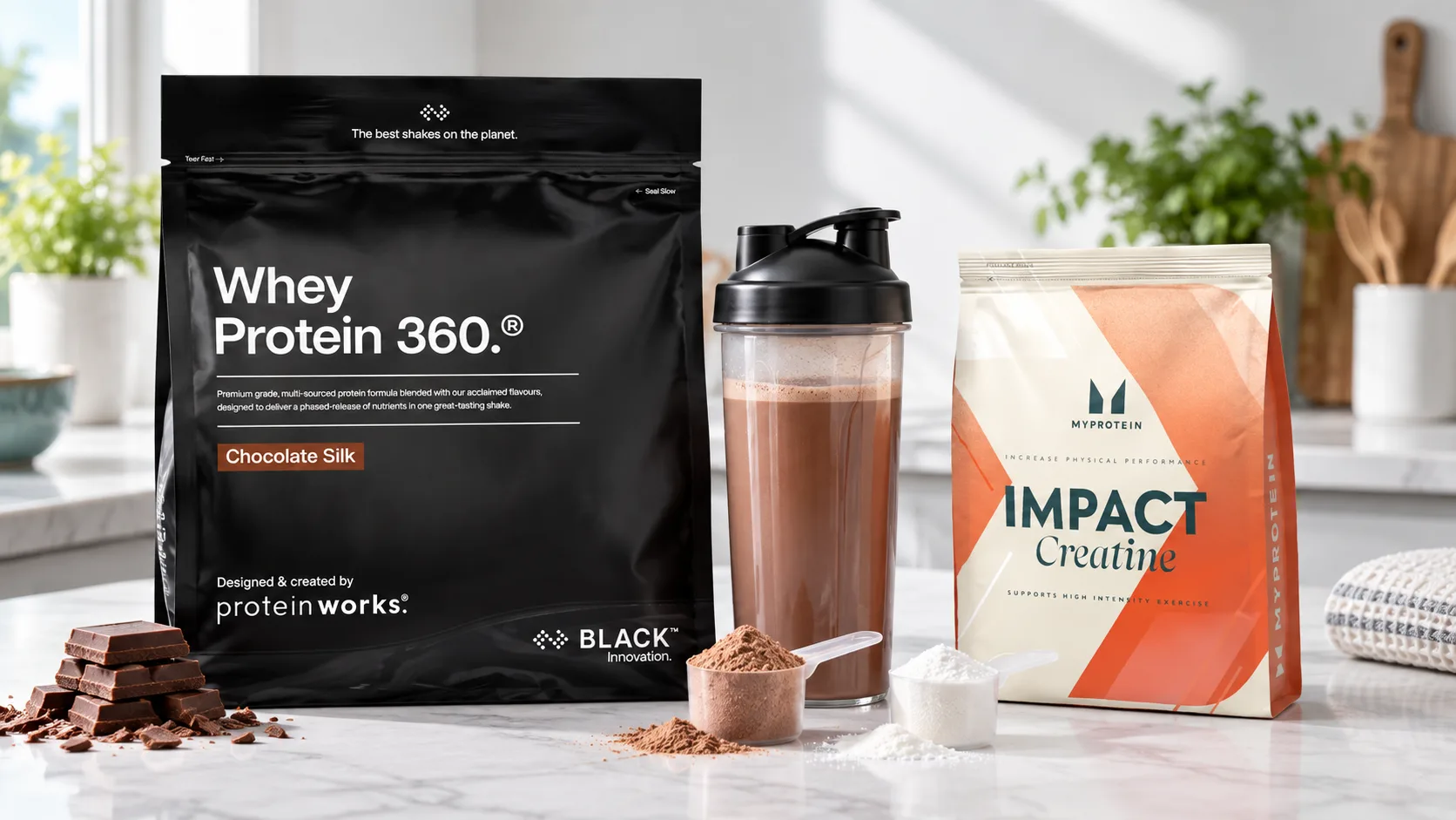 A bag of Protein Works Whey Protein 360 BLACK in Chocolate Silk and a bag of Myprotein Impact Creatine, with a chocolate protein shake, a scoop of whey and a scoop of creatine on a kitchen counter